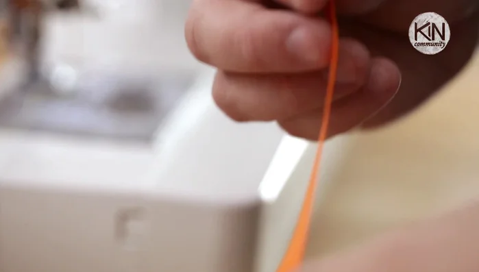 Create the hanging loop: Take 8 inches of ribbon, fold it in half, and sandwich the ends between two paper shapes. Sew a couple of back stitches to secure, then sew a straight line.