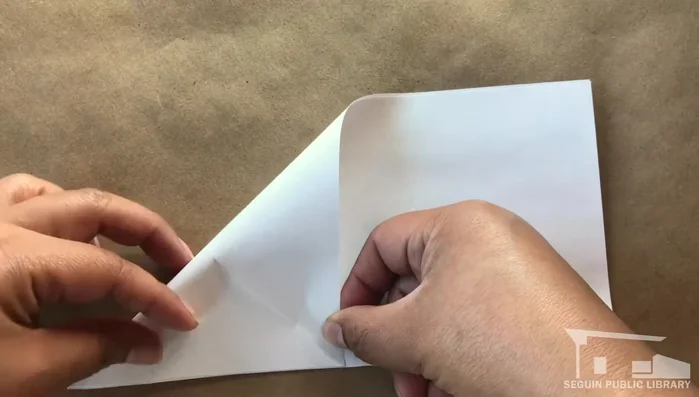 Line up the unfolded corner with the 'X' and crease.