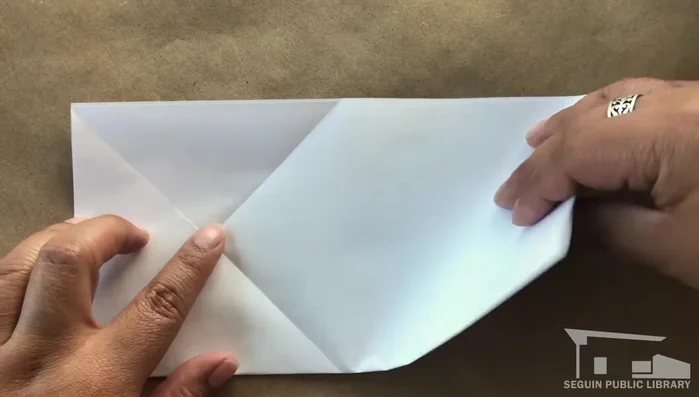 Line up the unfolded corner with the 'X' and crease.