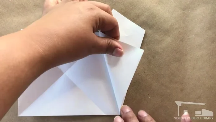 Fold the bottom edge of the other side to match the last fold and crease.