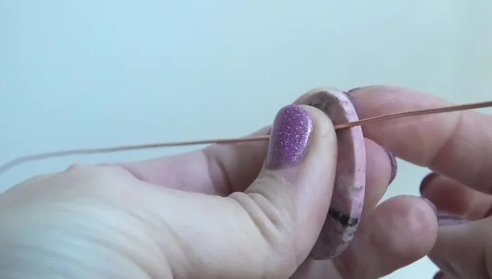 Curve the wires around the stone, keeping them flush against its sides and close together to avoid gaps.