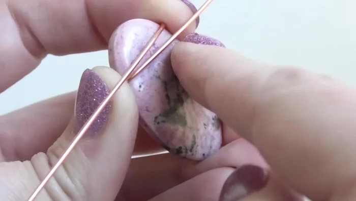 Bend the wires from the front to the back, ensuring they are above the middle line of the stone and near the top.