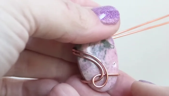 Bend the wires from the front to the back, ensuring they are above the middle line of the stone and near the top.