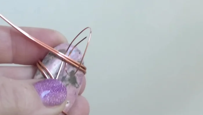 Bend the top wire upwards and the bottom wire downwards. Bend the top wire into a bail, ensuring it’s centered at the top of the stone.