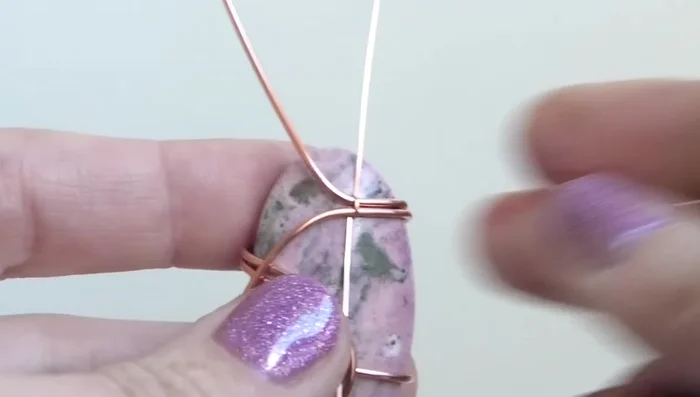 Bend the top wire upwards and the bottom wire downwards. Bend the top wire into a bail, ensuring it’s centered at the top of the stone.