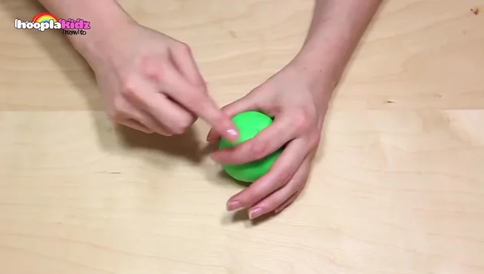 Create the stem and leaf: Roll a small piece of brown Play-Doh into a stem shape. Cut a leaf shape from dark green Play-Doh and add indentations with the knife. Attach both to the apple.