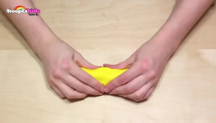 Make a banana: Roll yellow Play-Doh into a banana shape, tapering the ends. Add brown spots and a brown end using brown Play-Doh.