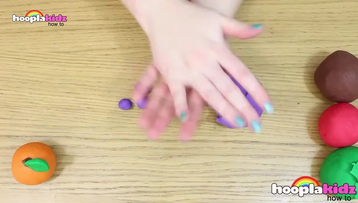 Make grapes: Roll many small balls of purple Play-Doh. Stick them together. Create a stem from brown Play-Doh and add green leaves.