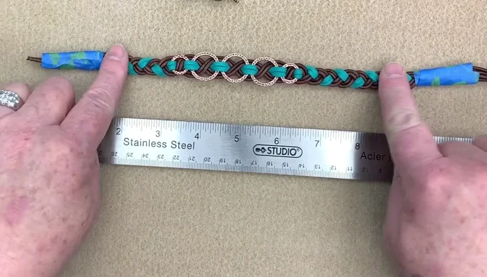 Measure and mark the bracelet length (wrist size + allowance + ribbon end length). Cut the braid.
