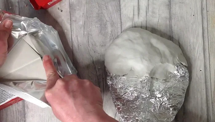 Add details like the nose, lips, and eyes, using tools like a table knife and your fingers to shape and smooth the clay. Use a damp cloth to prevent sections from drying out while working on other areas.