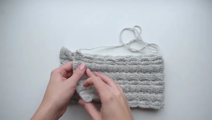 Using a crochet hook, seam the headband using a whip stitch, working under each edge stitch.