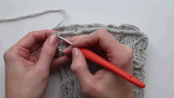 Using a crochet hook, seam the headband using a whip stitch, working under each edge stitch.