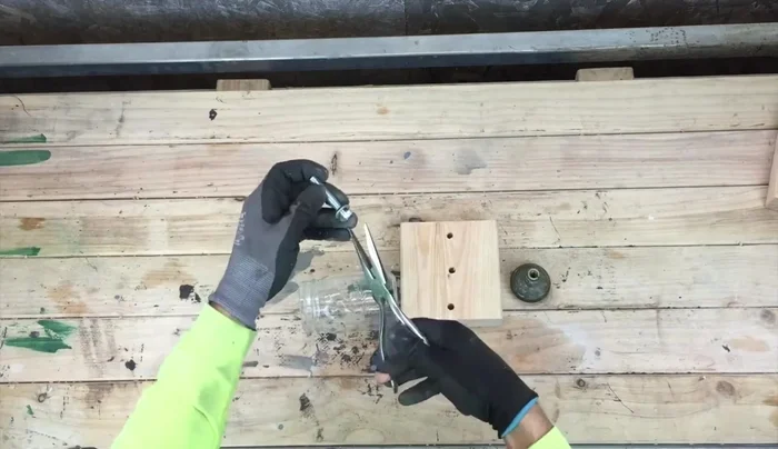 Assemble each planter: Place a washer on a screw, then use needle nose pliers to insert the screw through the drilled hole in the jar. Attach the wood block to the screw using a door knob, screwing it tight.