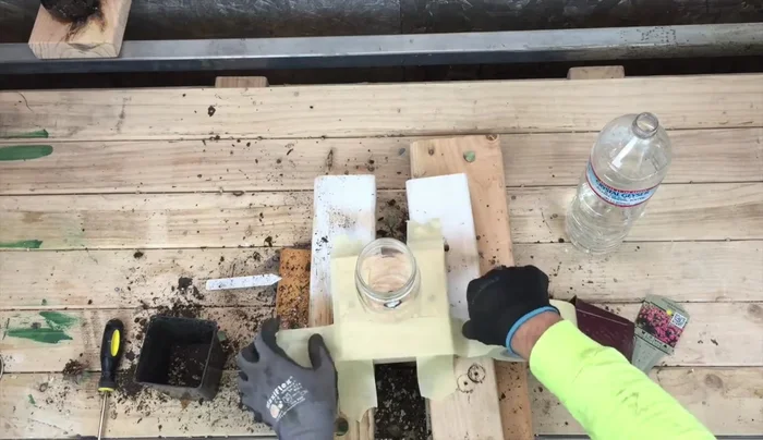 Prop up the planters to prevent spillage while filling with soil. Use tape to secure the sides temporarily. Fill the mason jars with soil and plant succulents.