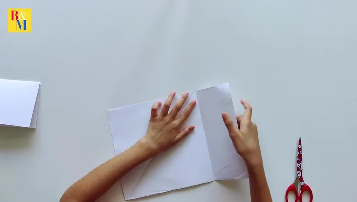 Cut another A4 sheet into a square for the house base. Fold it into a desired shape.