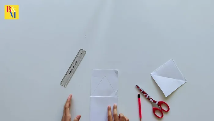 Draw and cut out the house walls on the other square paper. Consider a slightly slanted roof.