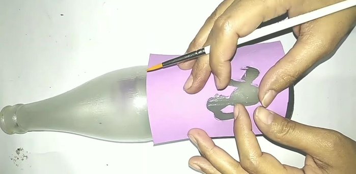 Paint the design: Paint the design onto the bottle using black acrylic paint. Add details and shadows as desired.
