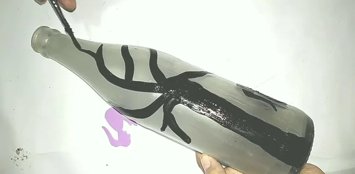 Add details: Add details like branches, grass, and flowers using black and red acrylic paint (or other colors). The example uses a dark color for contrast and red to make the red stand out at night.