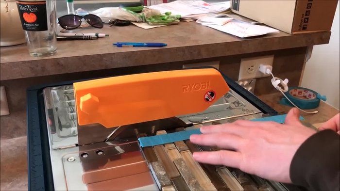 Mock up the backsplash to determine cut locations for electrical outlets and switches. Count the rows of tiles needed to clear the void.