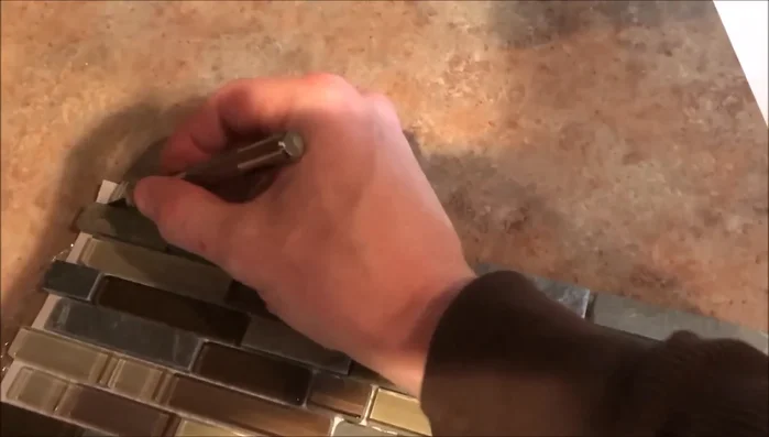 Remove excess tile rows if needed, such as when installing near a microwave. Tiles are easily removed and repositioned.