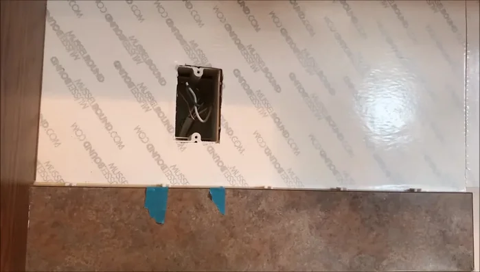 Mock up the backsplash to determine cut locations for electrical outlets and switches. Count the rows of tiles needed to clear the void.