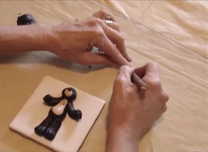 Insert two 4mm round beads for the eyes. Use the needle to make indentations for the eyebrows and mouth.