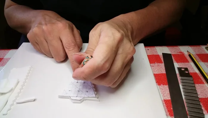 Use needle tool to create holes in the center of cutouts.