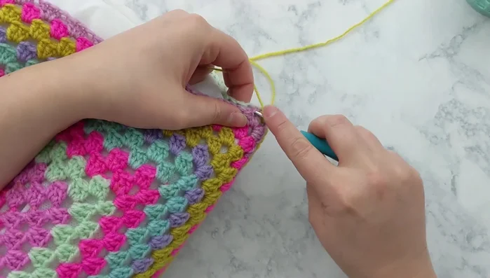 Close the opening: Single crochet the remaining open side to close the pillow cover.