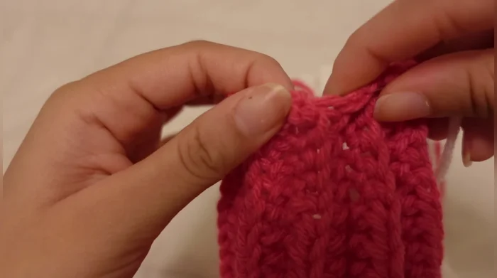 Weave in and out to close the hole at the top of the hat, pulling the yarn tight but not too tight to avoid ripping.