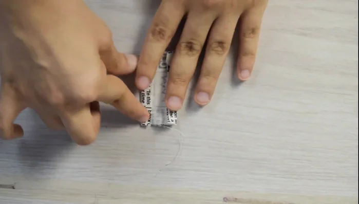 Finish the bottom: Fold the small rectangle 1 cm inward, press, and place it on the end of the zipper. Stitch.