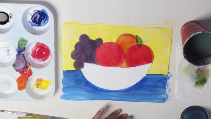 Paint the bowl black. Outline it first to avoid going outside the lines.