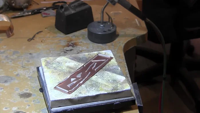 Melt the silver onto the copper using a soldering torch, ensuring even coverage and a good layer on the edges.