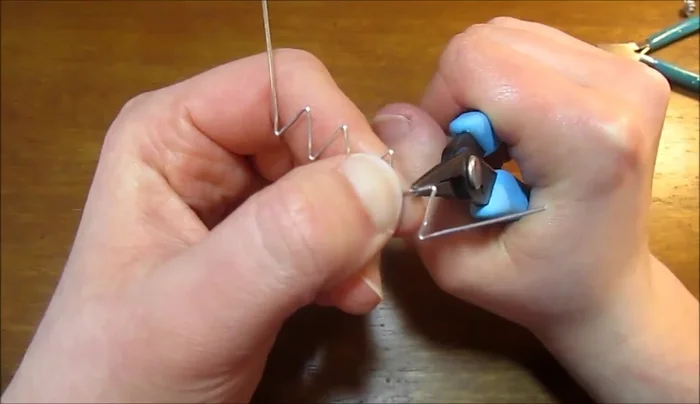 Curve the two remaining tails of each wire piece to form the fifth petal, ensuring consistent petal size.