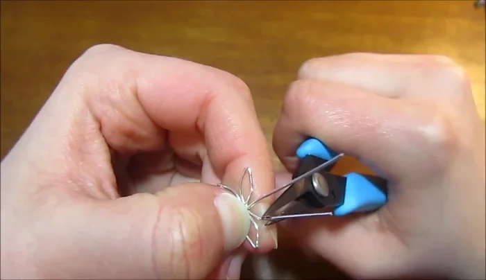 Curve the two remaining tails of each wire piece to form the fifth petal, ensuring consistent petal size.