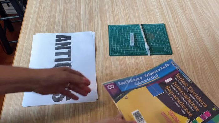 Secure the printed graphic onto a clear plastic index divider using packing tape.