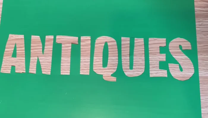 Secure any small cut-out pieces (like inner parts of letters) to the back of the stencil using packing tape.