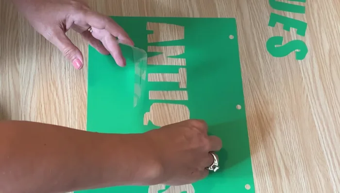 Secure any small cut-out pieces (like inner parts of letters) to the back of the stencil using packing tape.