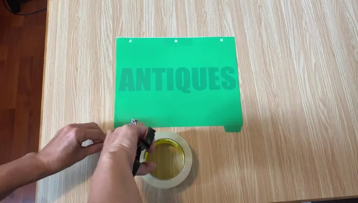 Secure the printed graphic onto a clear plastic index divider using packing tape.
