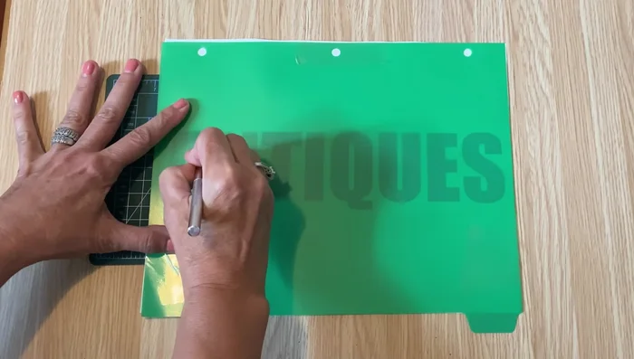 Secure any small cut-out pieces (like inner parts of letters) to the back of the stencil using packing tape.