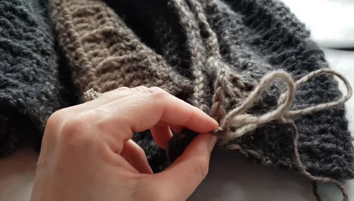 If using a needle, thread your yarn and gently pull it out to create a loop for seaming. Ensure you have enough yarn.