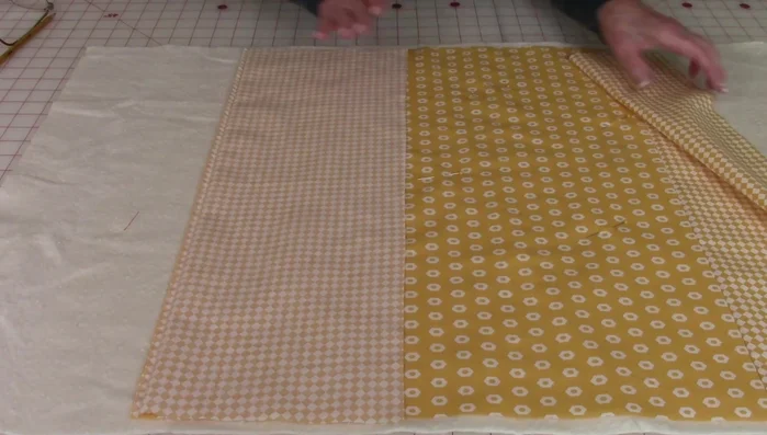 Place the smaller pieces onto the sides of the larger front piece, aligning edges. Pin and stitch 1/4 inch along the seams. Press the seams to the back.