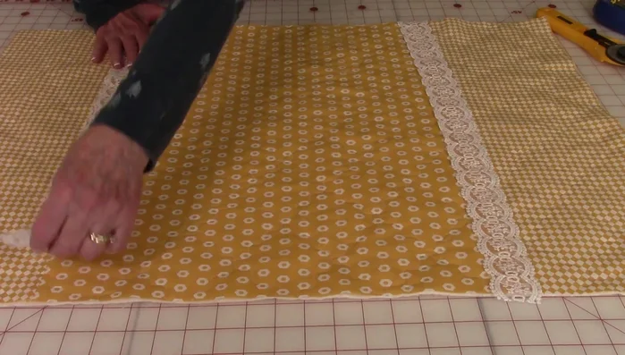 Place the lace (if using) over the center seam and pin it down. Stitch along each side of the lace, trimming excess ribbon.