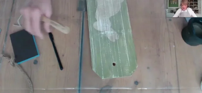 Paint the tag with a light-colored base coat to cover the previous design and create a light background for the decoupage paper.