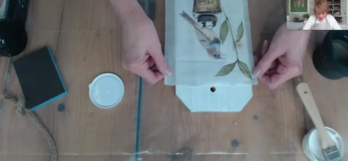 Apply a top coat of decoupage medium to seal the paper.