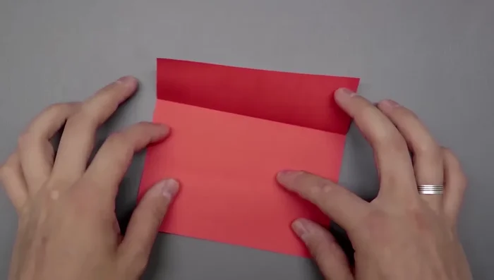 Rotate the square and divide it into thirds again, using the same 'S' curve and crease method as before.