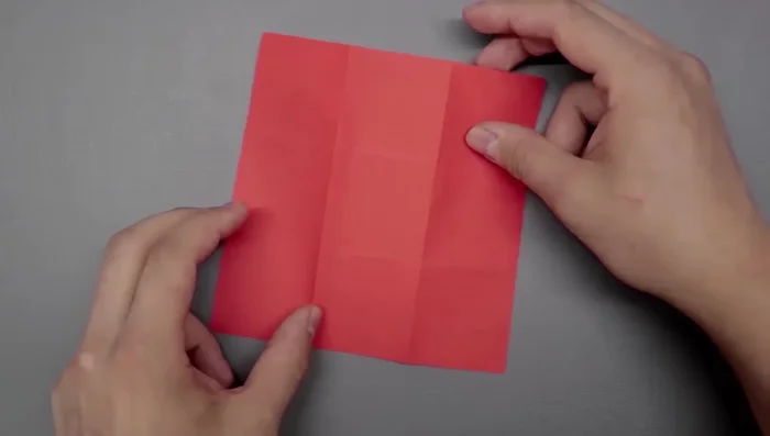 Create two new folds on the right side by bringing the corner to the left side of the middle square, and repeat on the left side.