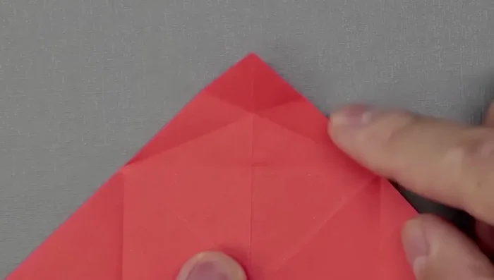 Fold the top corner and close. Now bring both sides to the middle; the paper should naturally assume the fish shape. 