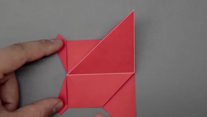 Repeat this for the other side of the tail, but keep the flap down and fold diagonally. Tuck in any extra paper to refine the shape.