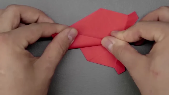 Repeat this for the other side of the tail, but keep the flap down and fold diagonally. Tuck in any extra paper to refine the shape.