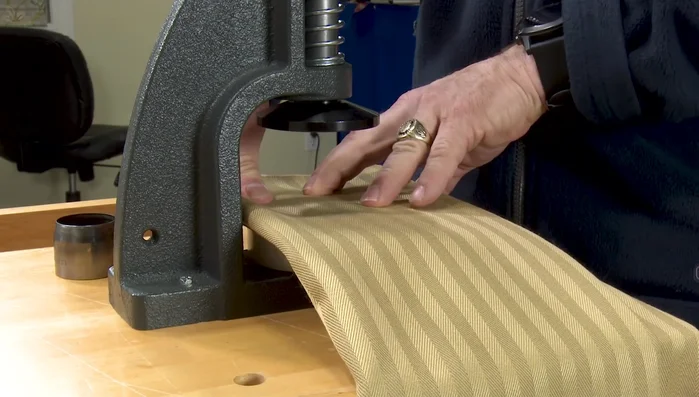 Use the hole cutter to create a hole in the center of the fabric circle.